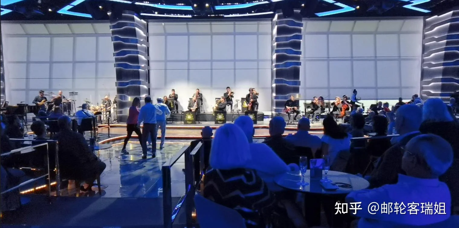 旅客在邮轮室内观景休息区听音乐